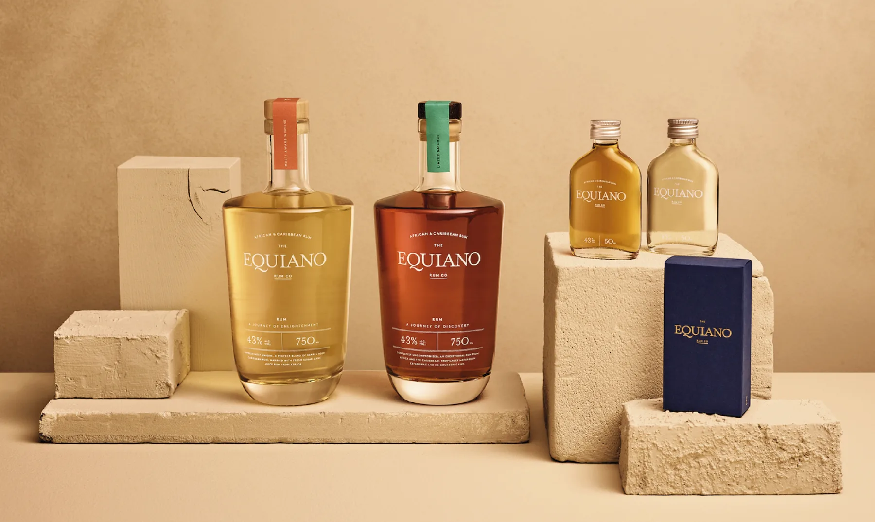 Equiano Caribbean rum bottles and packaging arranged on textured stone blocks.